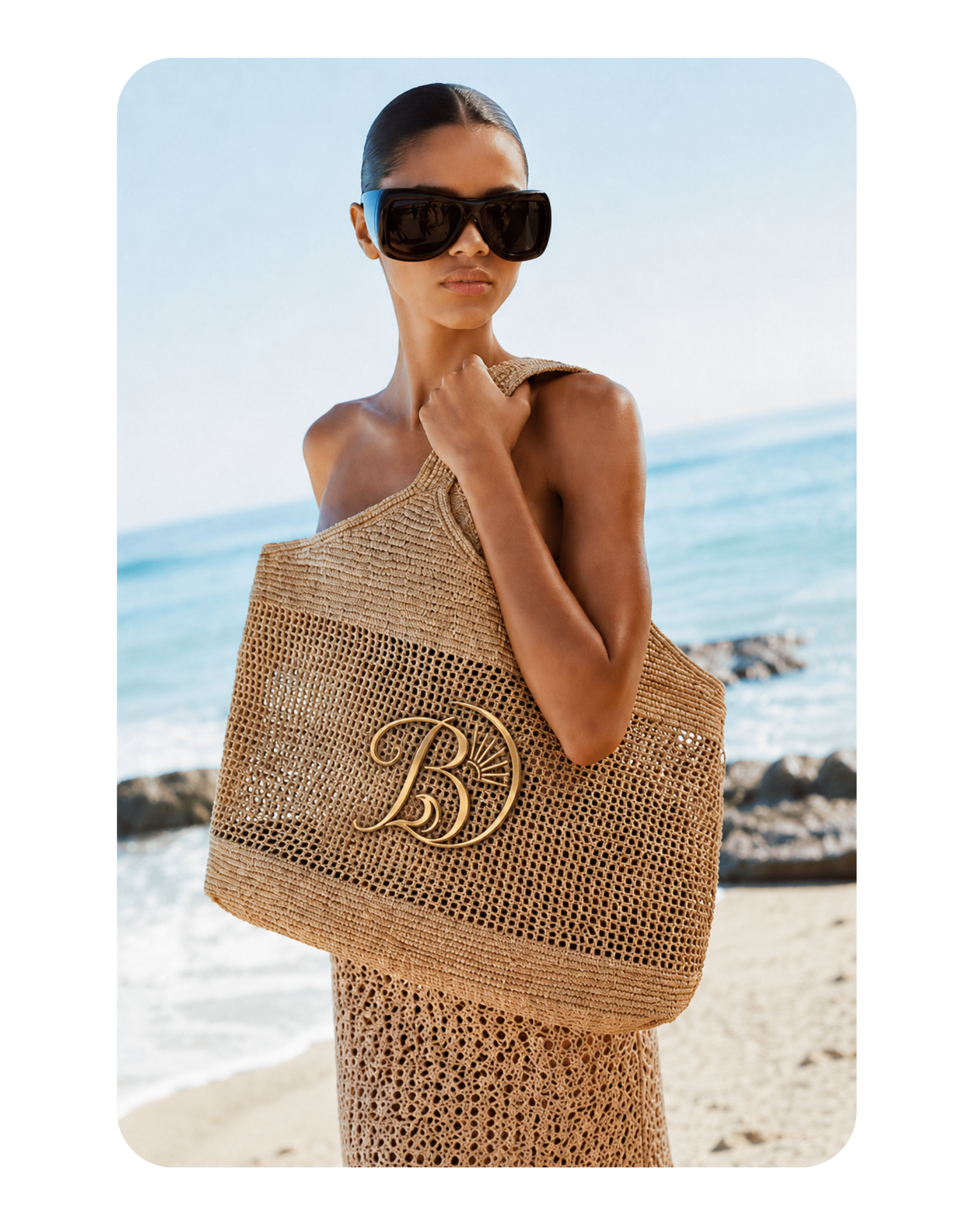 Bolso tejido con monograma dorado en la playa